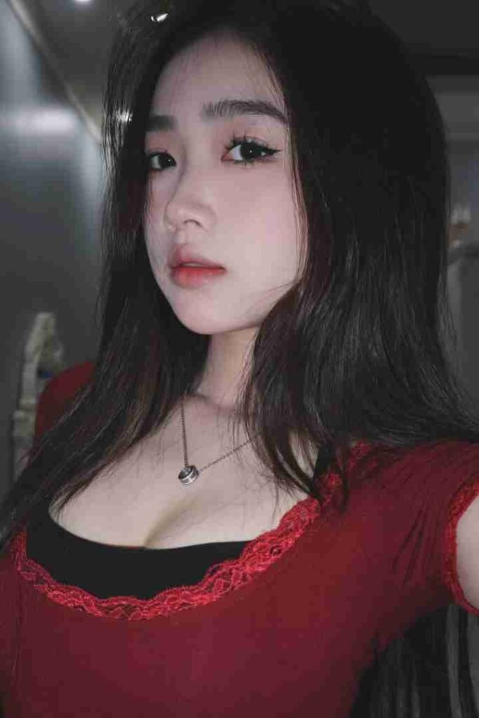 KL Escort Girl Attractive Asian woman with long black hair wearing a red top and a necklace. Sex Call Girl