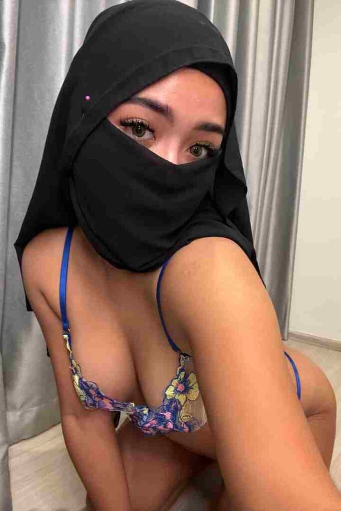 KL Escort Girl Woman in niqab and bra, kneeling. Revealing and modest fashion contrast. Sex Call Girl