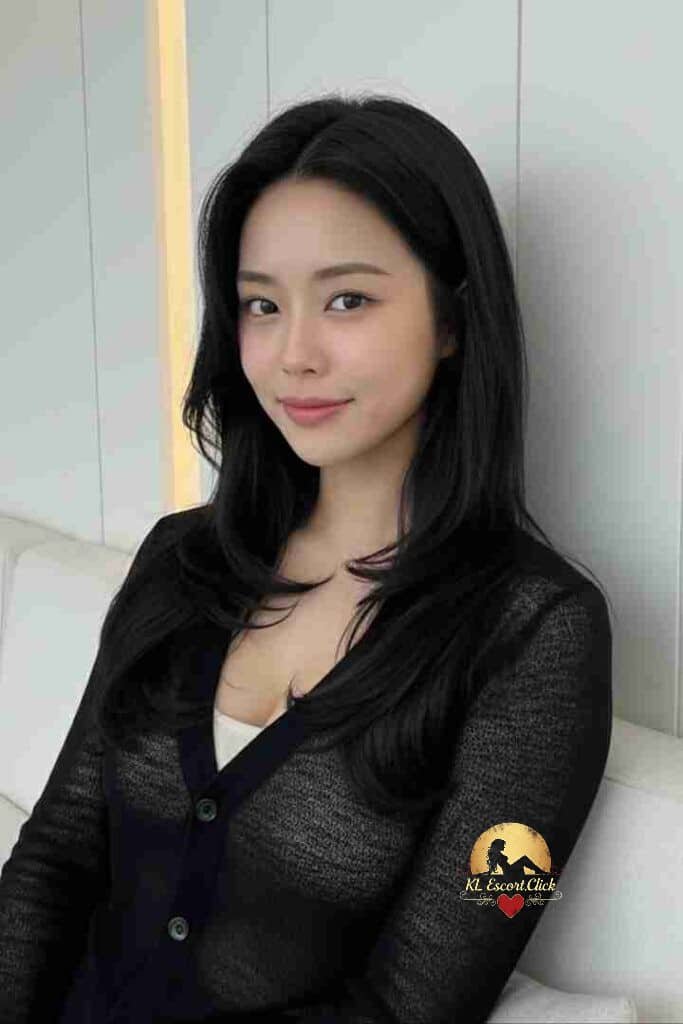 Beautiful Asian woman with long black hair, wearing a sheer black cardigan and white top. Smiling gently.
