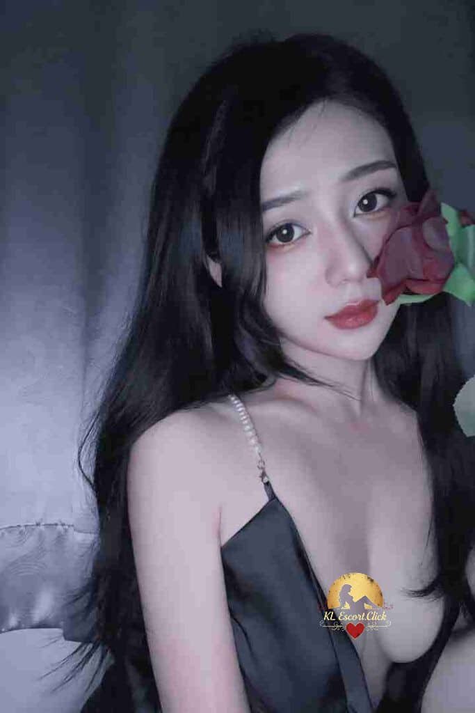 Elegant Asian woman with rose, wearing black dress. Soft lighting and makeup, dark hair.