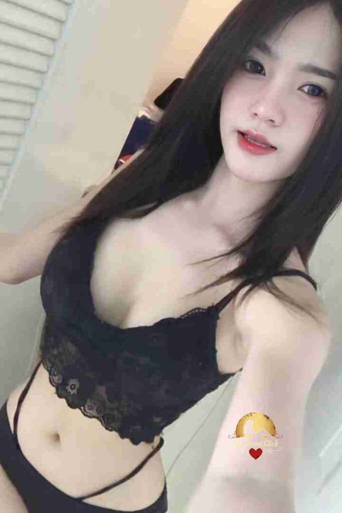 Pretty Asian woman in black lingerie top and bottoms with long dark hair, looking at the camera.