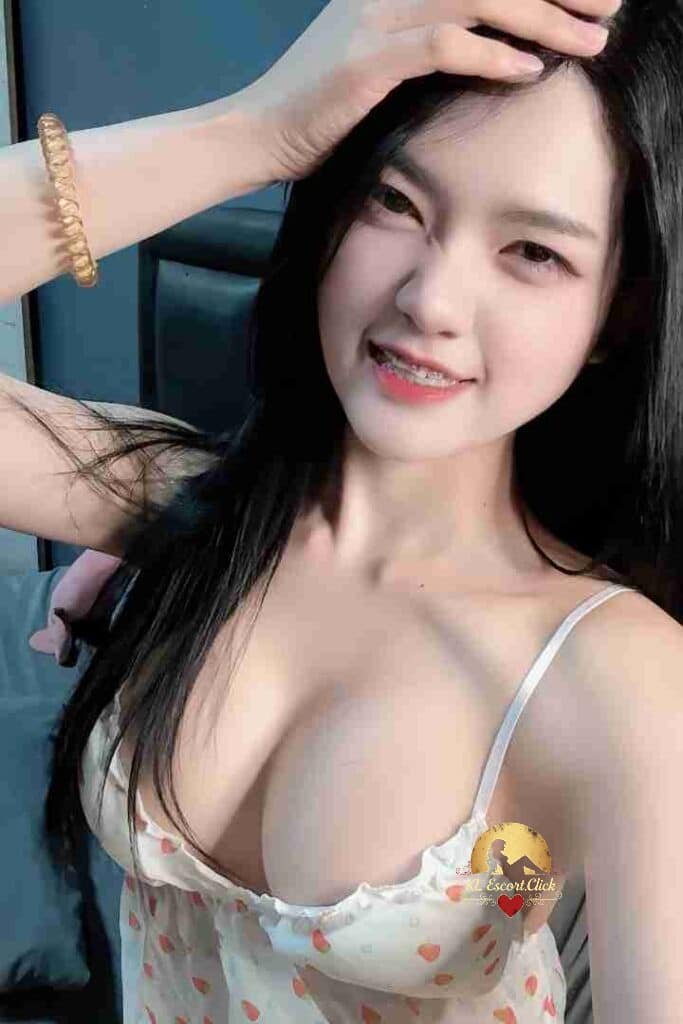 Smiling Asian woman with braces in lingerie, posing with hand on head. Dark hair, fair skin.