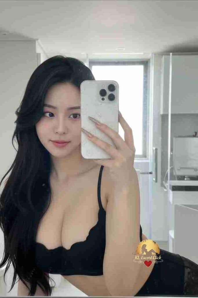 Seductive Asian woman in black lingerie taking mirror selfie. Long dark hair, bedroom setting.