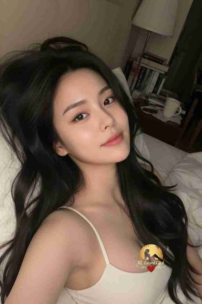 Beautiful Asian woman with long dark hair in white top, lying down. Sensual and alluring portrait.