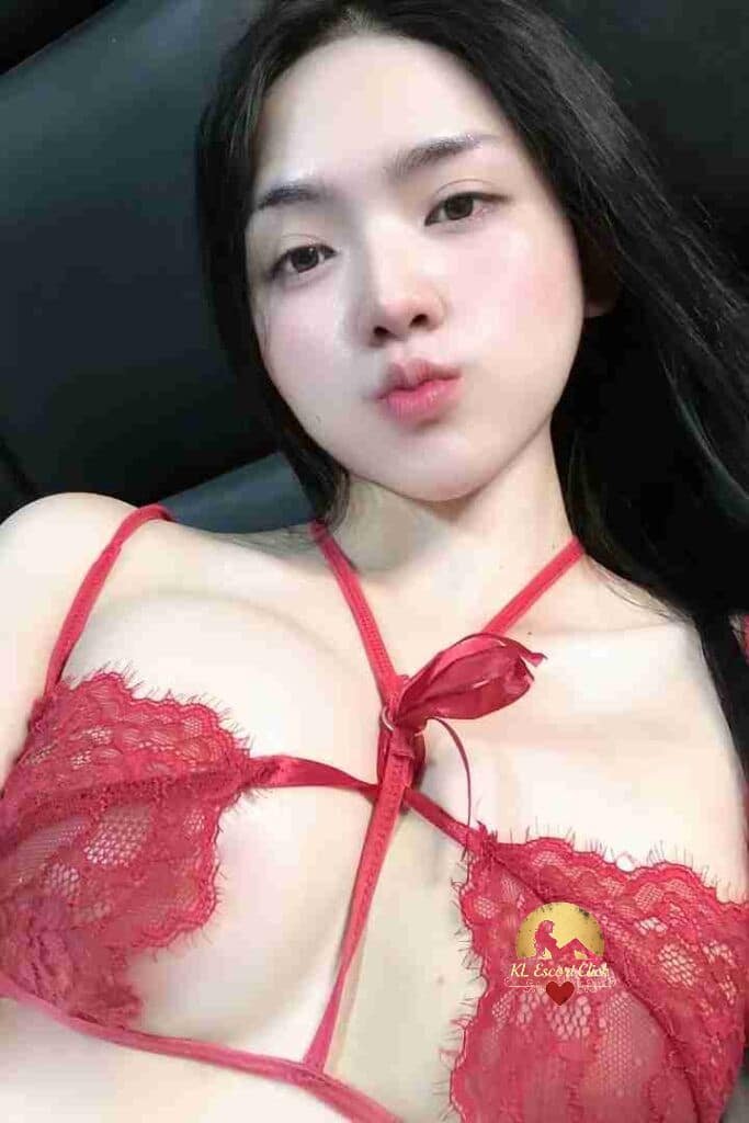 Asian woman in red lace lingerie with a pout. Portrait close-up, fair skin, dark hair.