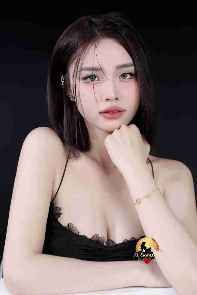 Attractive Vietnamese woman with short dark hair, delicate features, and a black lace top. Elegant pose.