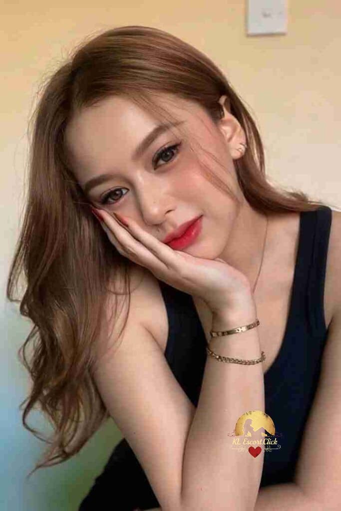 KL Escort Girl Smiling Asian woman in black tank top with soft, wavy hair, looking to the side. Sex Call Girl