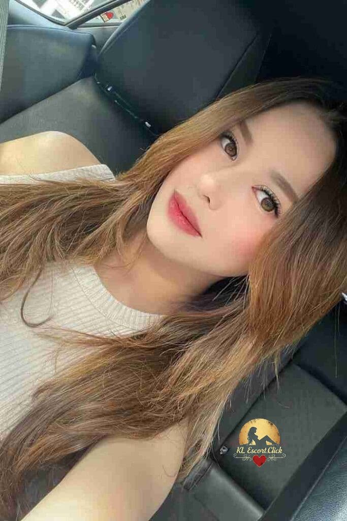 KL Escort Girl Woman in blue lace lingerie smiles while lying on a bed. Sex Call Girl