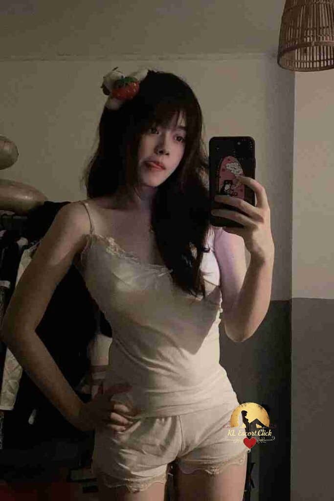 Attractive Vietnamese woman in lingerie taking selfie with phone.