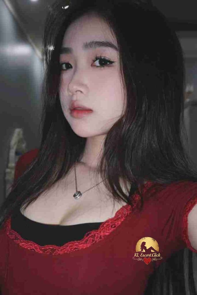 Attractive Vietnamese woman with dark hair and red top. C-cup escort in KL.