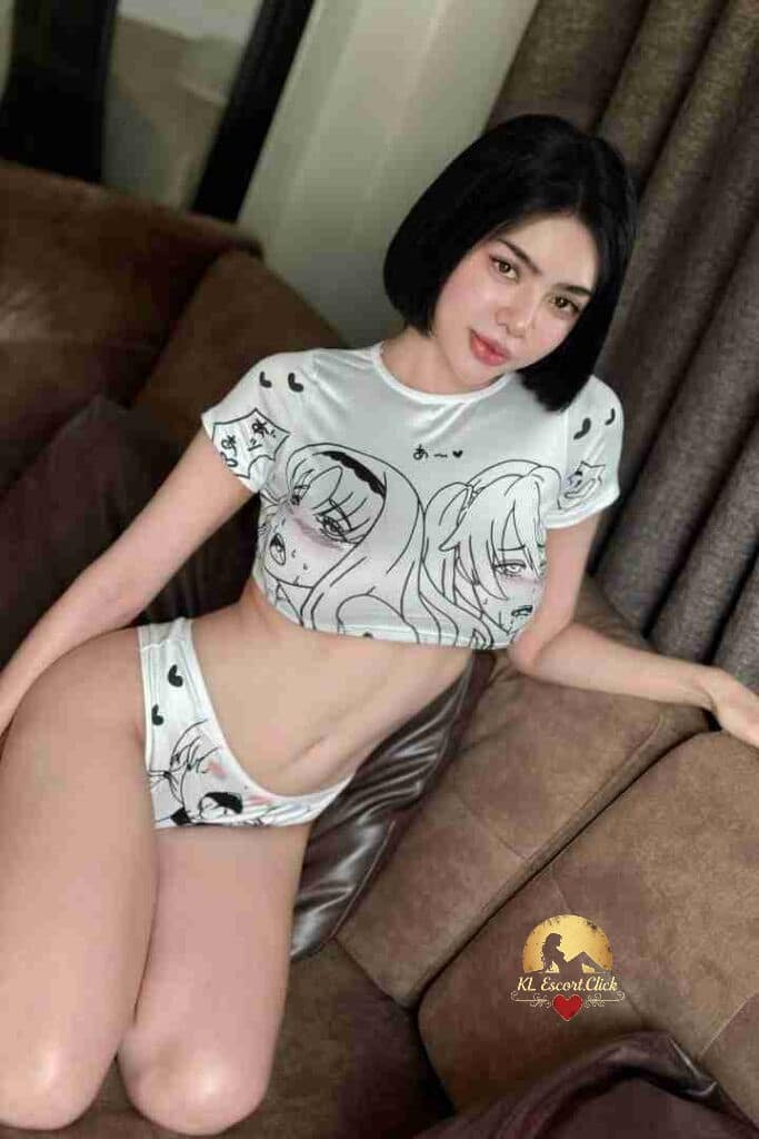 Woman in anime-themed crop top and briefs poses on sofa.