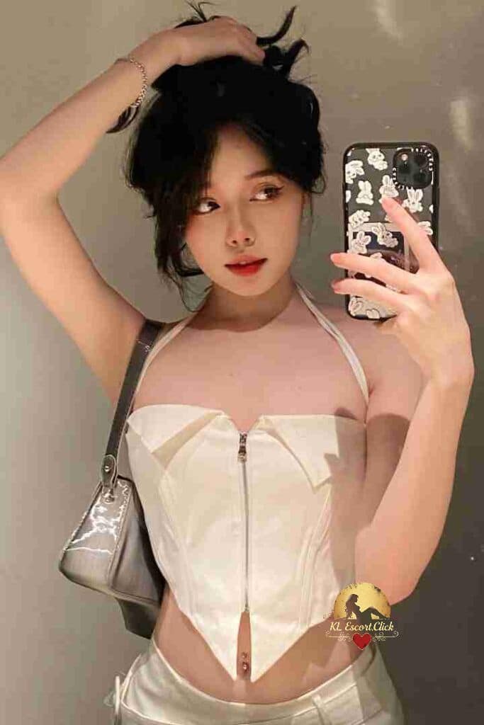 Attractive young woman in white corset top taking selfie.