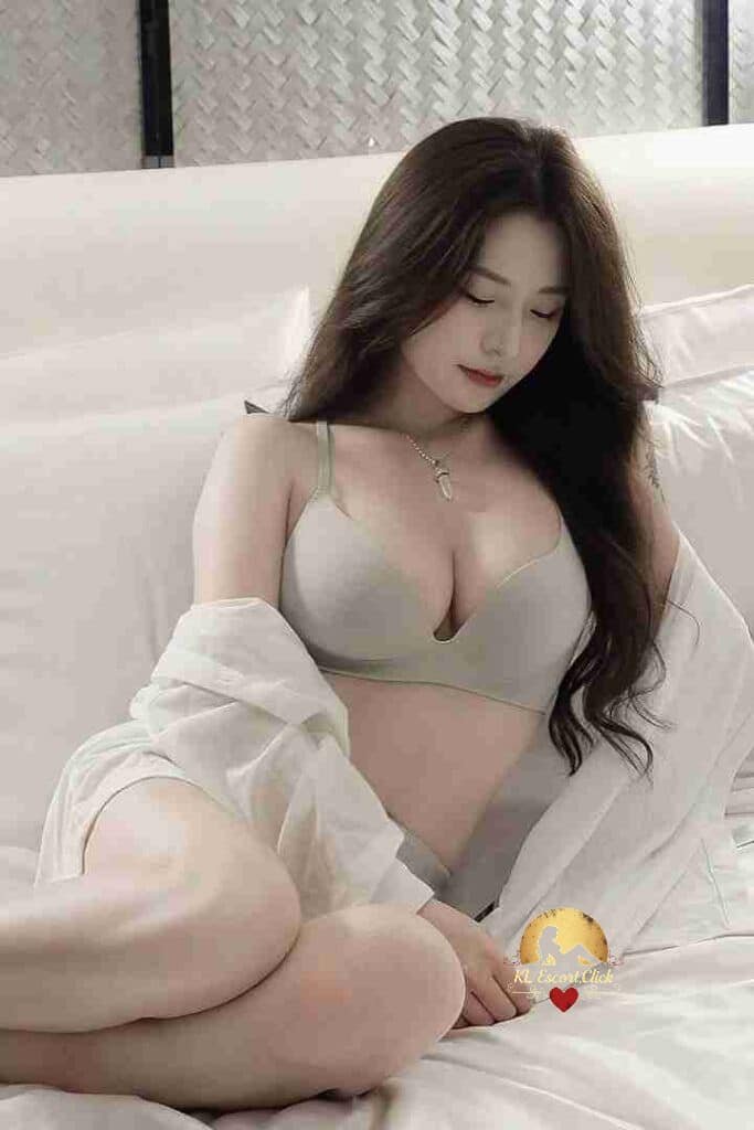Yu Xin relaxing in bed wearing bra and shirt. Gentle relaxing girl services in KL.